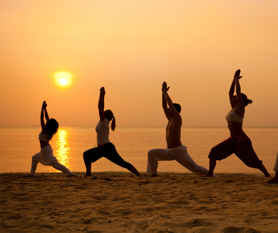 Clase de yoga al amanecer en la playa